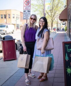 Two locals posing with their new bags after shopping in downtown Ames. 