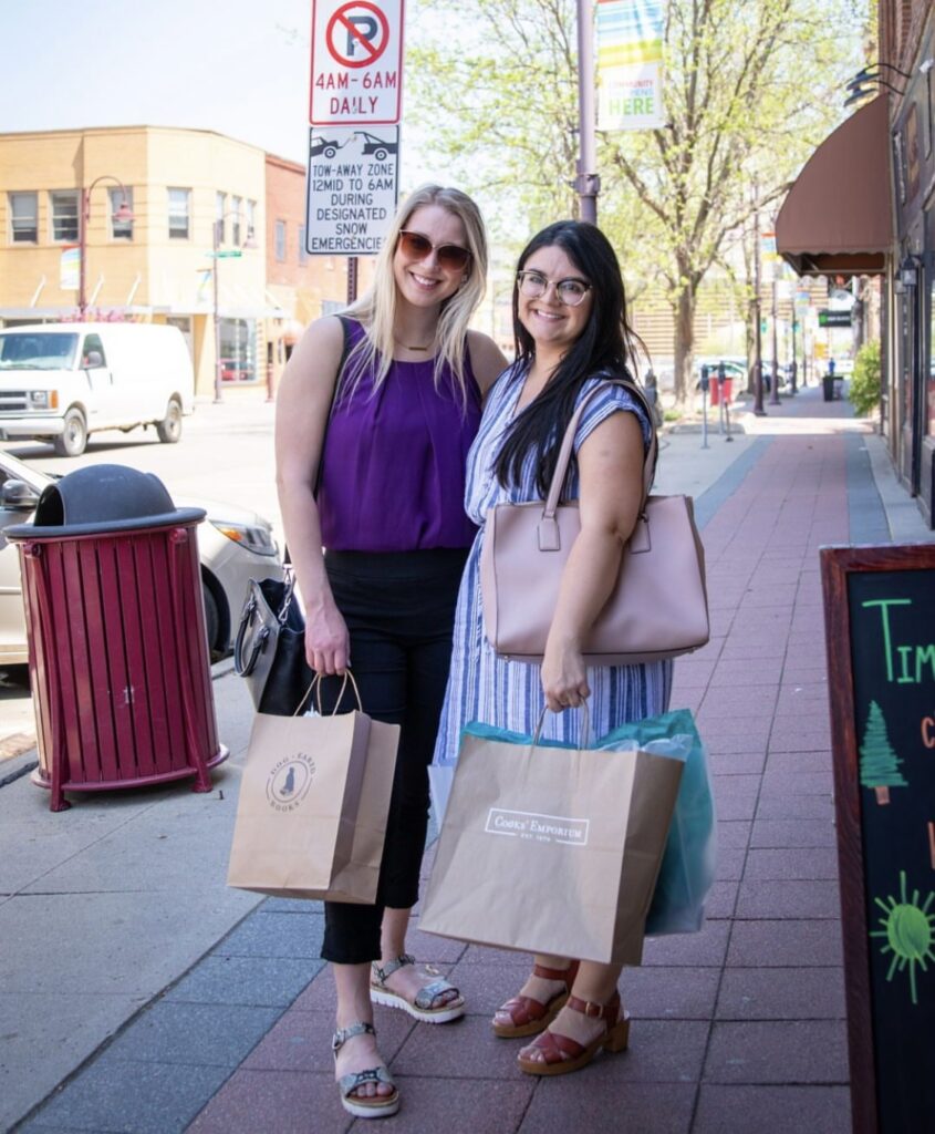 Two locals posing with their new bags after shopping in downtown Ames.