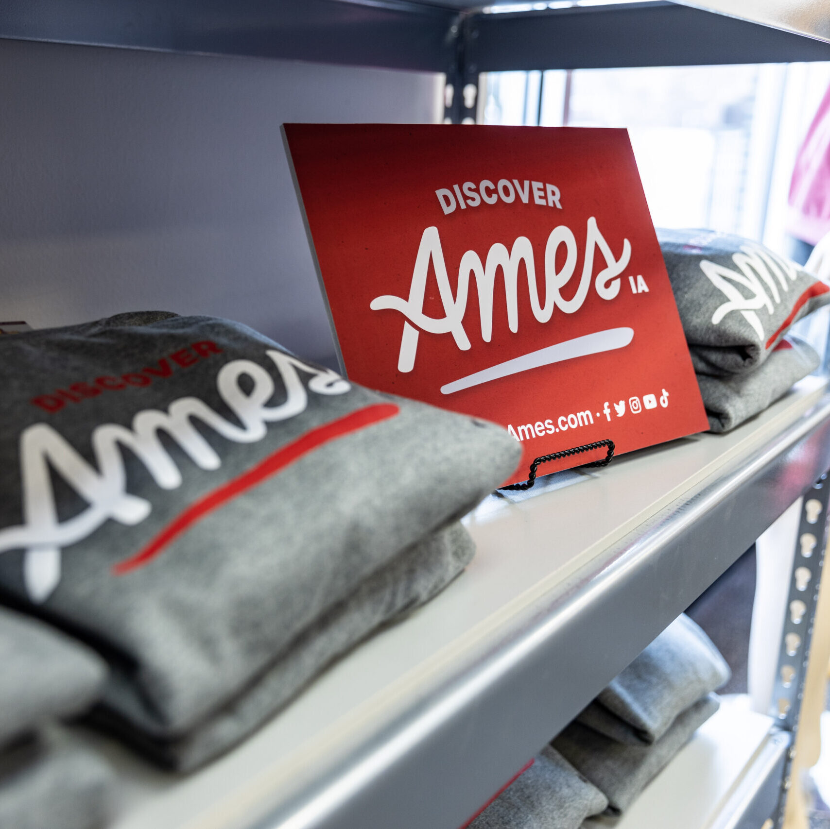 tshirts, hats, and other exclusive Discover AMes merchandise are now available for purchase at Dogtown University in Campustown