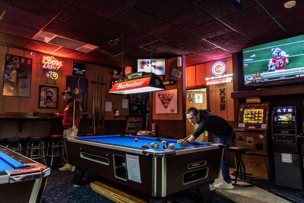 Two guys in a game of pool at Welch Ave. Station.