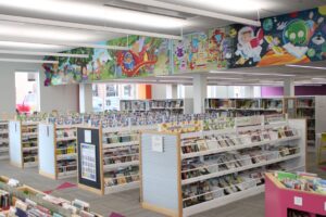 A mural and a spread of children's books available to check out at Ames Public Library. 